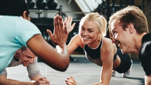 Four fitness professionals planking and doing high fives